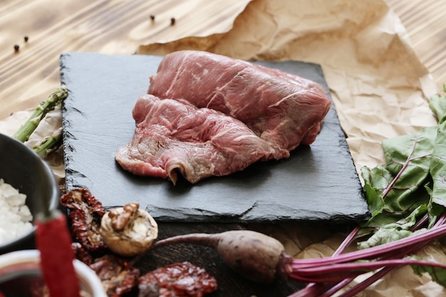 Carne cruda con ingredienti per cucinare il pasto