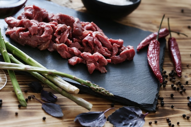 Carne cruda con ingredienti per cucinare il pasto