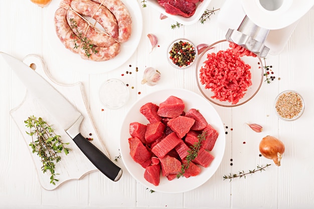 Carne cruda tritata. Il processo di preparazione della carne forzata per mezzo di un tritacarne. Salsiccia fatta in casa Carne di manzo macinata. Vista dall'alto