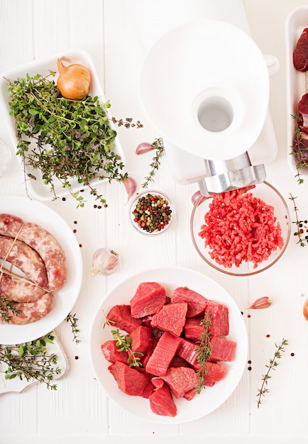 Carne cruda tritata. Il processo di preparazione della carne forzata per mezzo di un tritacarne. Salsiccia fatta in casa Carne di manzo macinata. Vista dall'alto