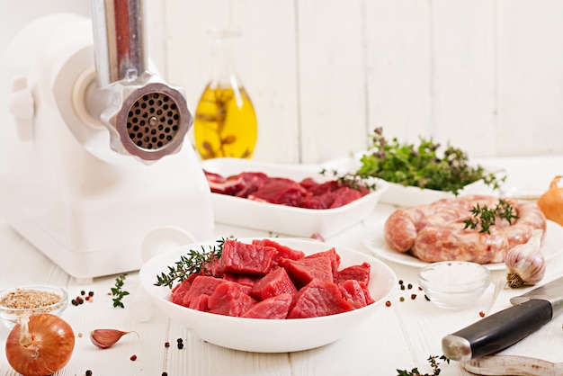 Carne cruda tritata. Il processo di preparazione della carne forzata per mezzo di un tritacarne. Salsiccia fatta in casa Carne di manzo macinata.