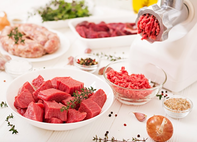 Carne cruda tritata. Il processo di preparazione della carne forzata per mezzo di un tritacarne. Salsiccia fatta in casa Carne di manzo macinata.