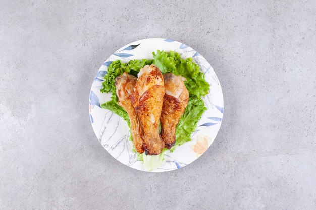 Carne di cosce di pollo alla griglia con lattuga sul piatto bianco