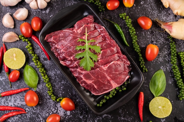 Carne di maiale cruda a fette usata per cucinare con peperoncino, pomodoro, basilico e semi di peperone fresco.