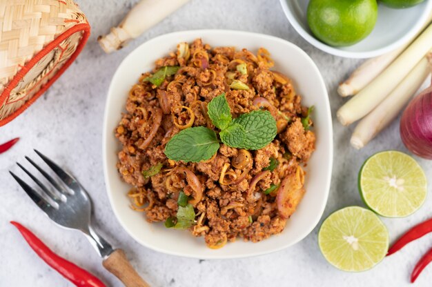 Carne di maiale tritata piccante in un piatto bianco.