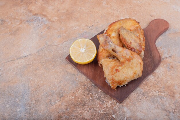 Carne di pollo alla griglia con limone su un piatto di legno