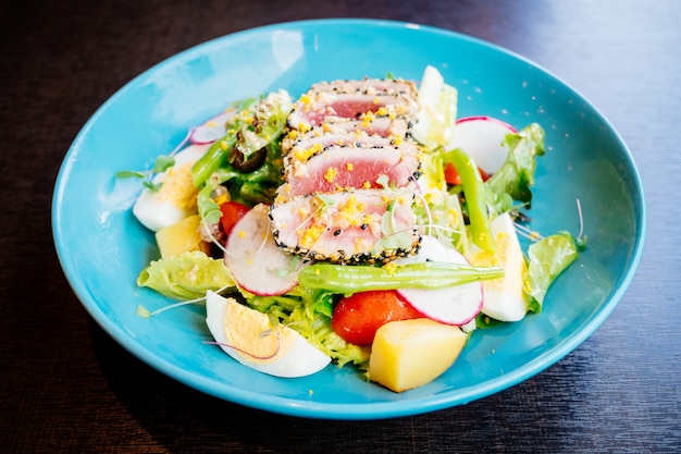 Carne di tonno cruda e fresca con sesamo e insalata