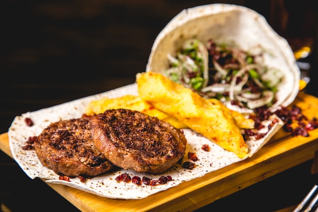 Carne fritta con la patata e il onin mescolati con la vista laterale di verdi