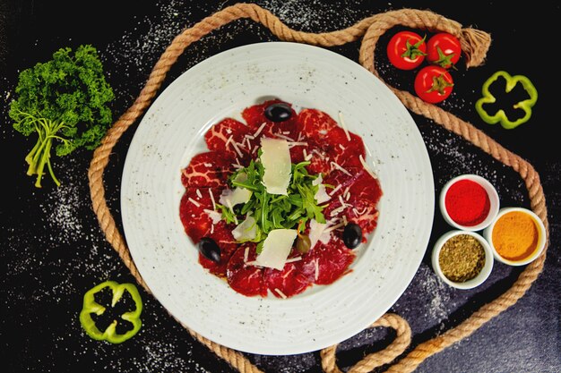 Carpaccio di manzo con parmigiano, rucola e olive