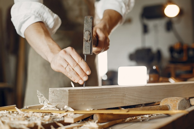 Carpentiere bello che lavora con un legno