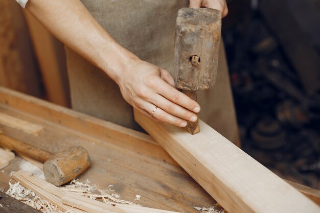 Carpentiere bello che lavora con un legno