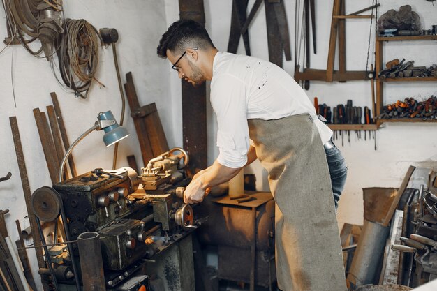 Carpentiere bello che lavora con un legno