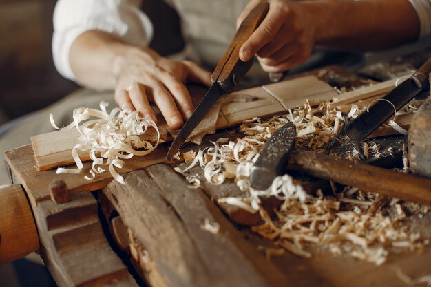 Carpentiere bello che lavora con un legno