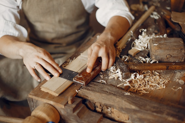 Carpentiere bello che lavora con un legno