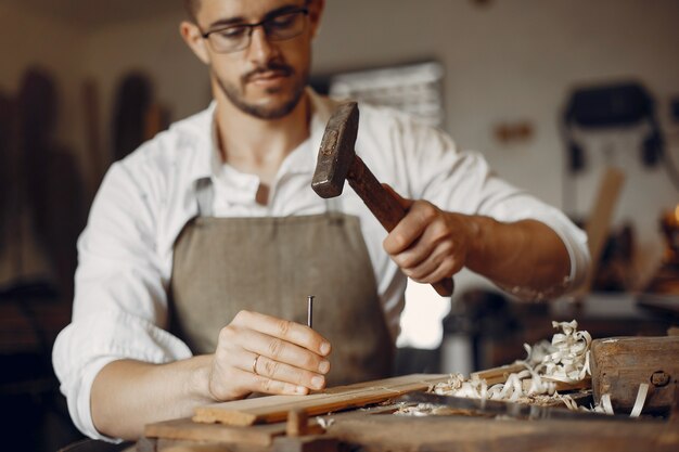 Carpentiere bello che lavora con un legno