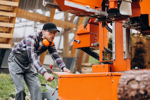 Carpentiere che lavora su una segheria su una fabbricazione di legno