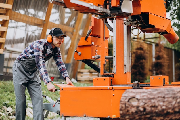 Carpentiere che lavora su una segheria su una fabbricazione di legno