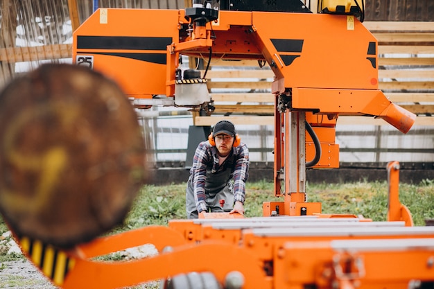 Carpentiere che lavora su una segheria su una fabbricazione di legno