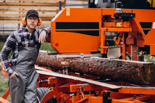 Carpentiere che lavora su una segheria su una fabbricazione di legno