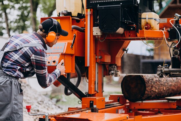 Carpentiere che lavora su una segheria su una fabbricazione di legno