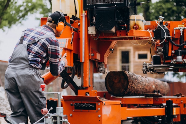 Carpentiere che lavora su una segheria su una fabbricazione di legno