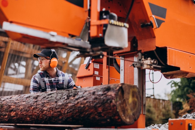 Carpentiere che lavora su una segheria su una fabbricazione di legno