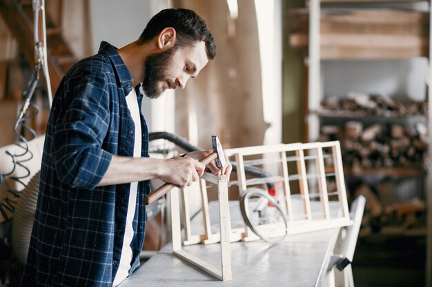 Carpentiere che martella un chiodo in un'officina