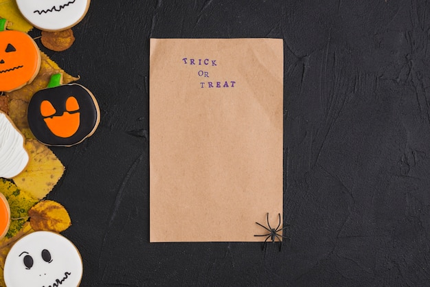 Carta artigianale con ragno vicino a pan di zenzero e fogliame