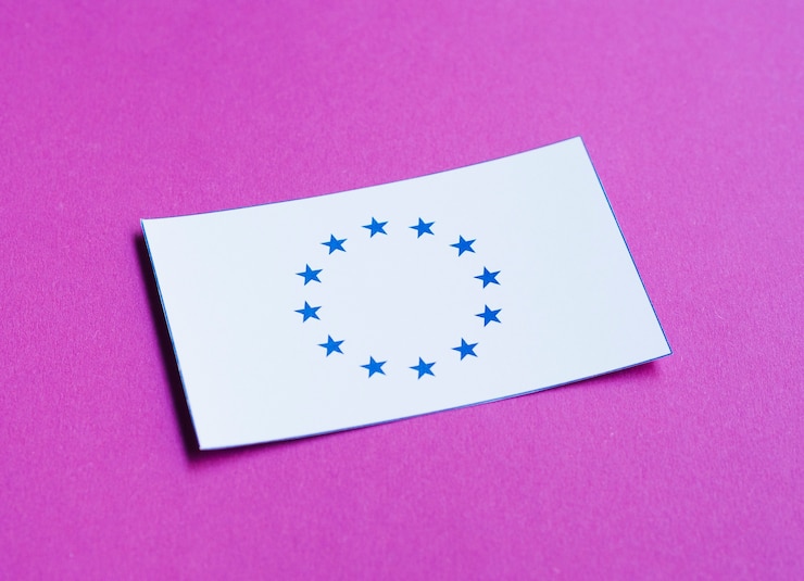 Foto gratuito carta bianca con bandiera europea su sfondo viola