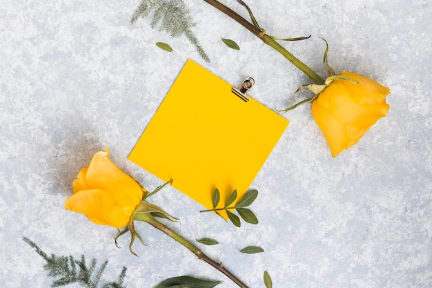 Carta bianca con fiori di rosa sul tavolo