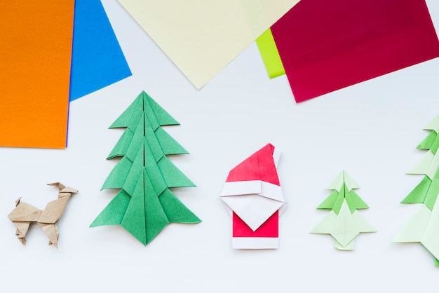 Carta colorata e albero di Natale fatto a mano; renna; origami di carta Babbo Natale isolato su sfondo bianco