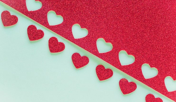Foto gratuito carta con piccoli cuori tagliati sul tavolo