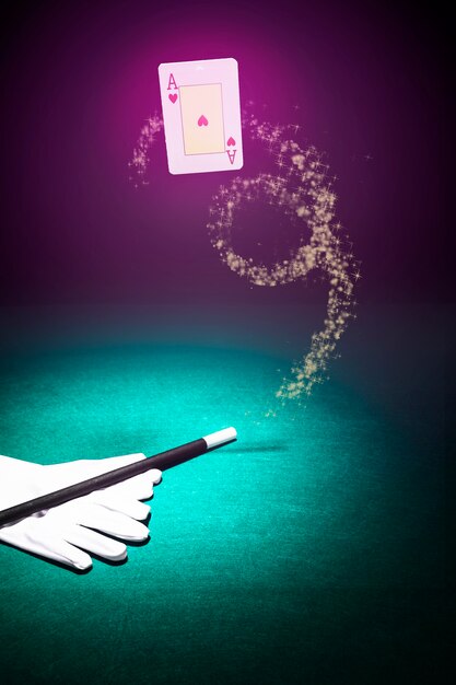 Carta da gioco in aria con un paio di guanti bianchi e bacchetta su sfondo colorato