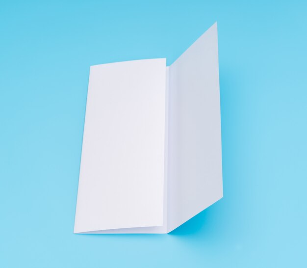 Carta di modello bianco trifold su sfondo blu.
