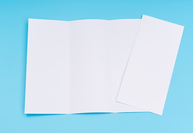 Carta di modello bianco trifold su sfondo blu.