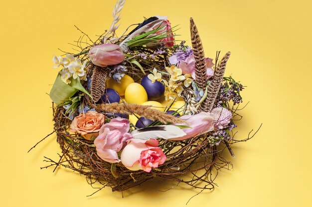 Carta di pasqua. Uova di Pasqua dipinte in nido su giallo