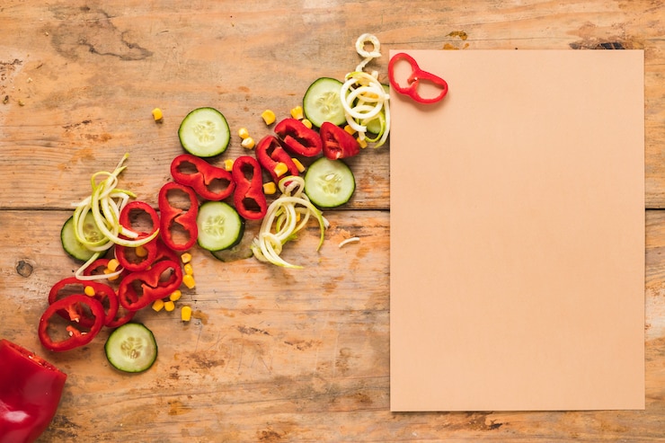 Foto gratuito carta marrone bianca oltre a tagliare la paprika; cetriolo e mais sul tavolo di legno