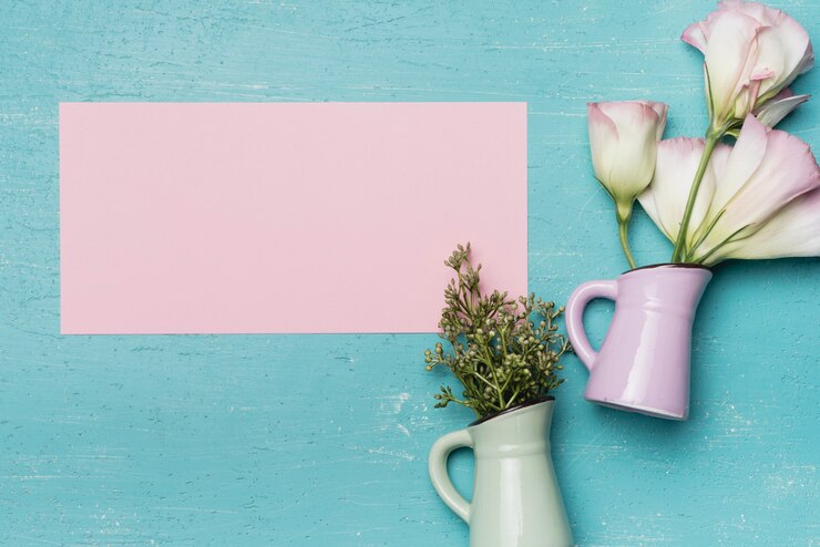Foto gratuito carta rosa vuota con due vasi in ceramica su sfondo blu