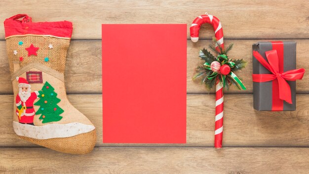 Carta vicino a calza di Natale, canna e scatola regalo