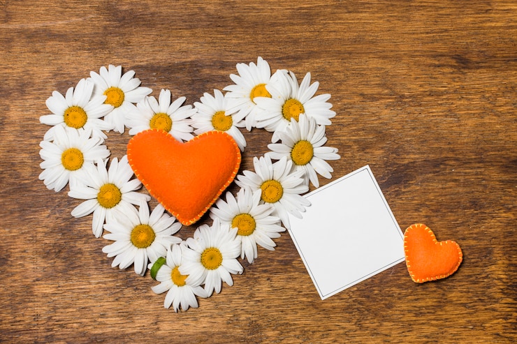Foto gratuito carta vicino al cuore ornamentale di fiori bianchi e giocattoli arancioni