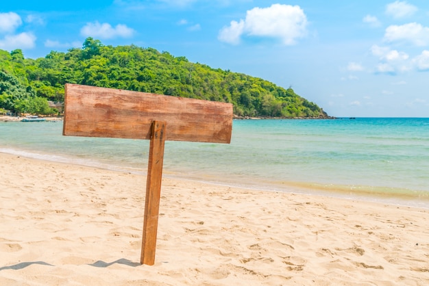 Cartello in legno sulla spiaggia tropicale