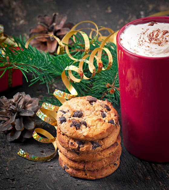 Cartolina di Natale con una tazza di caffè rossa condita con panna montata