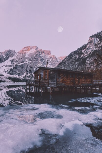 Casa di legno marrone vicino alla montagna innevata