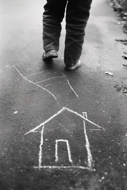 Casa disegnata con il gesso sulla strada da un uomo