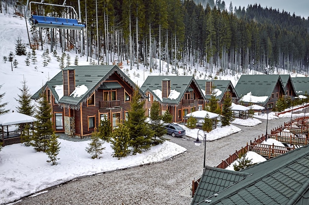 Casa in legno per vacanze invernali in montagna ricoperte di neve e cielo blu. Sci davanti alla casa.