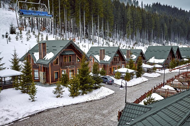 Casa in legno per vacanze invernali in montagna ricoperte di neve e cielo blu. Sci davanti alla casa.