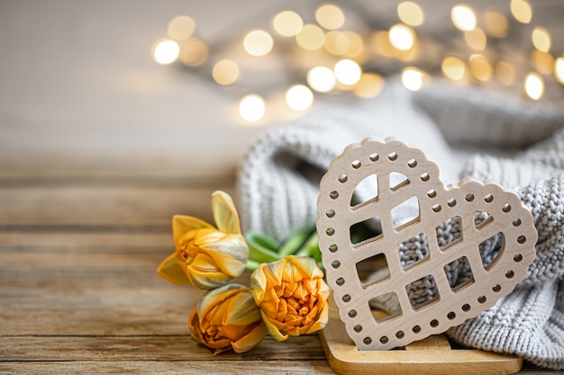 Casa romantica natura morta con cuore decorativo in legno e elemento lavorato a maglia su sfondo sfocato con spazio di copia bokeh.