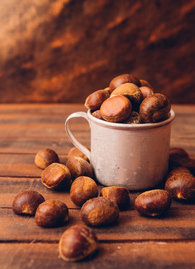 Foto gratuito castagne di vista laterale in tazza sulla tavola di legno