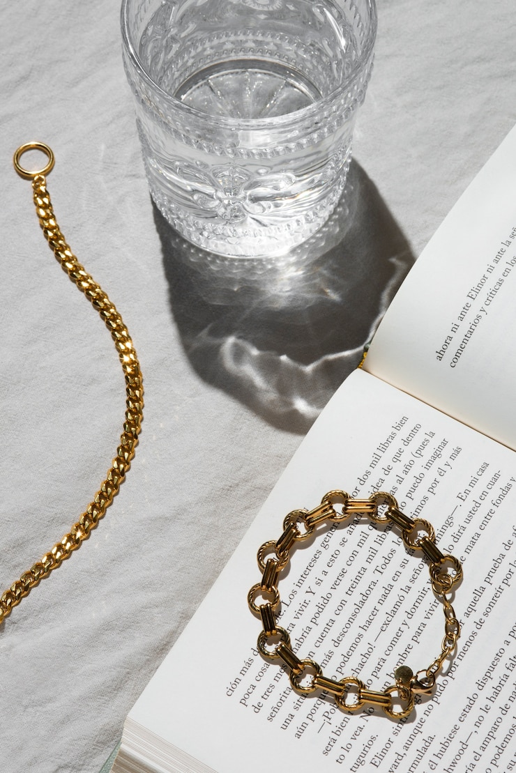Foto gratuito catene d'oro ad alto angolo e libro