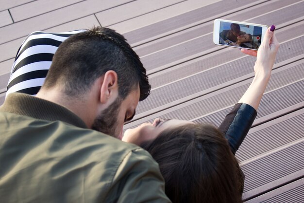 Cattura momenti luminosi. Giovane coppia felice allegra facendo selfie sulla fotocamera mentre è in piedi all&#39;aperto.